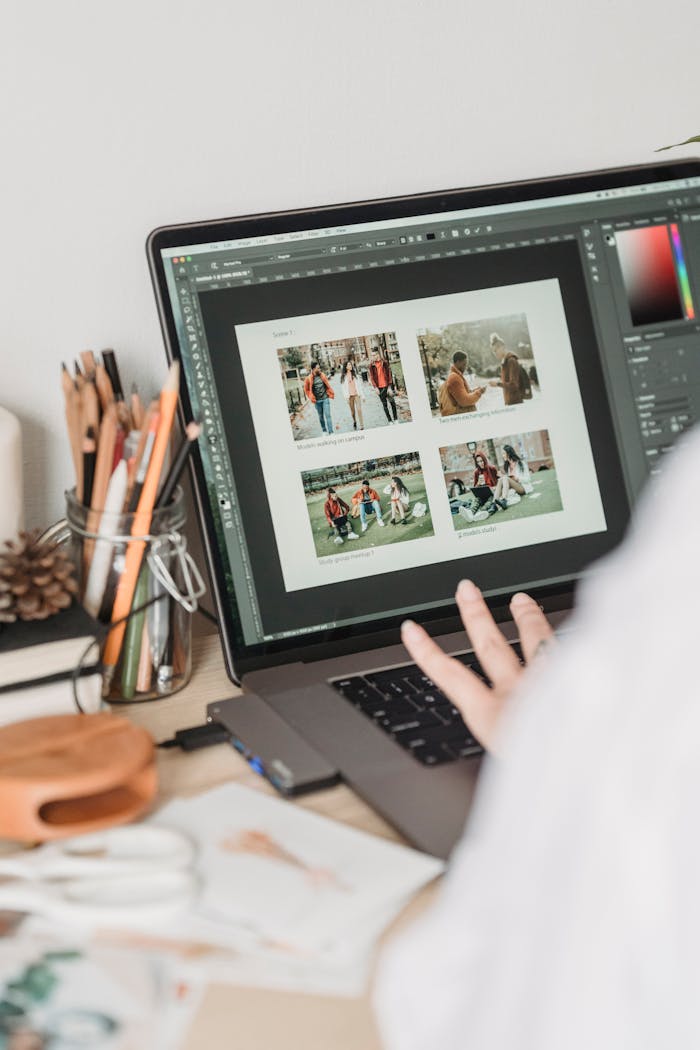 Crop unrecognizable female freelancer using touchpad while retouching photos on laptop during remote work at home