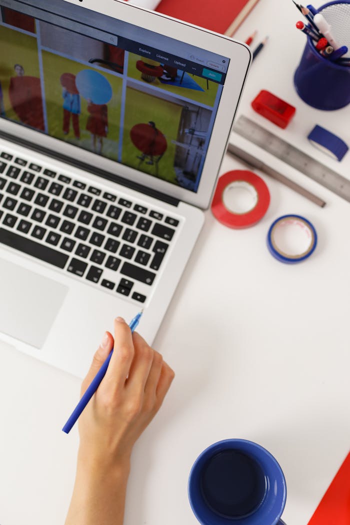 A colorful home office setup with a laptop, coffee, and creative tools at a workspace.